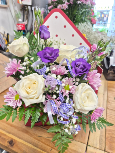 Violet Cottage - A charming envelope arrangement in crisp whites, pretty pinks and vibrant purples, finished with fresh greenery and playful gingham ribbon. Envelopes may vary.