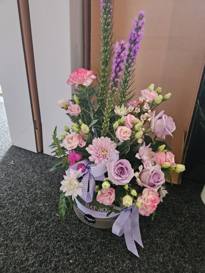 Lilac Dreams - A graceful hatbox arrangement in soft pink and lilac tones, perfect for making someone feel special.