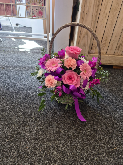 Pink Promise - A charming basket arrangement in pretty pink and purple tones, finished with a statement bow.