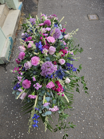 Purple Meadow Casket Spray - A natural casket spray in rich purple and pink shades, offering a thoughtful final tribute.