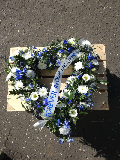 Forever in Our Hearts Wreath - A graceful blue and white wreath offering a heartfelt expression of love and remembrance.