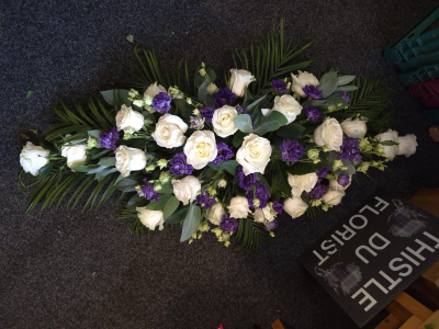 Purple Grace Casket Spray - An elegant casket spray in white and purple tones, carefully arranged as a loving tribute.